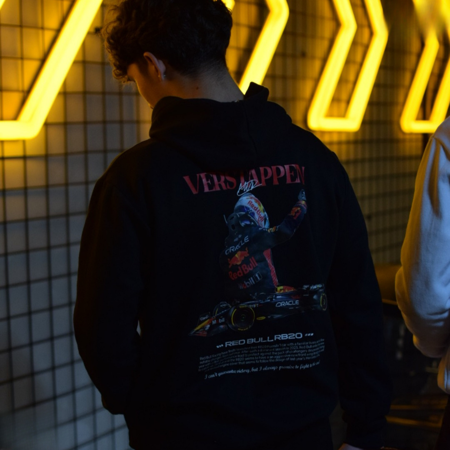 Black and white Formula 1 hoodies featuring Verstappen’s name and Red Bull RB20 car graphic on the back, and a minimalist red Formula 1 logo on the front chest