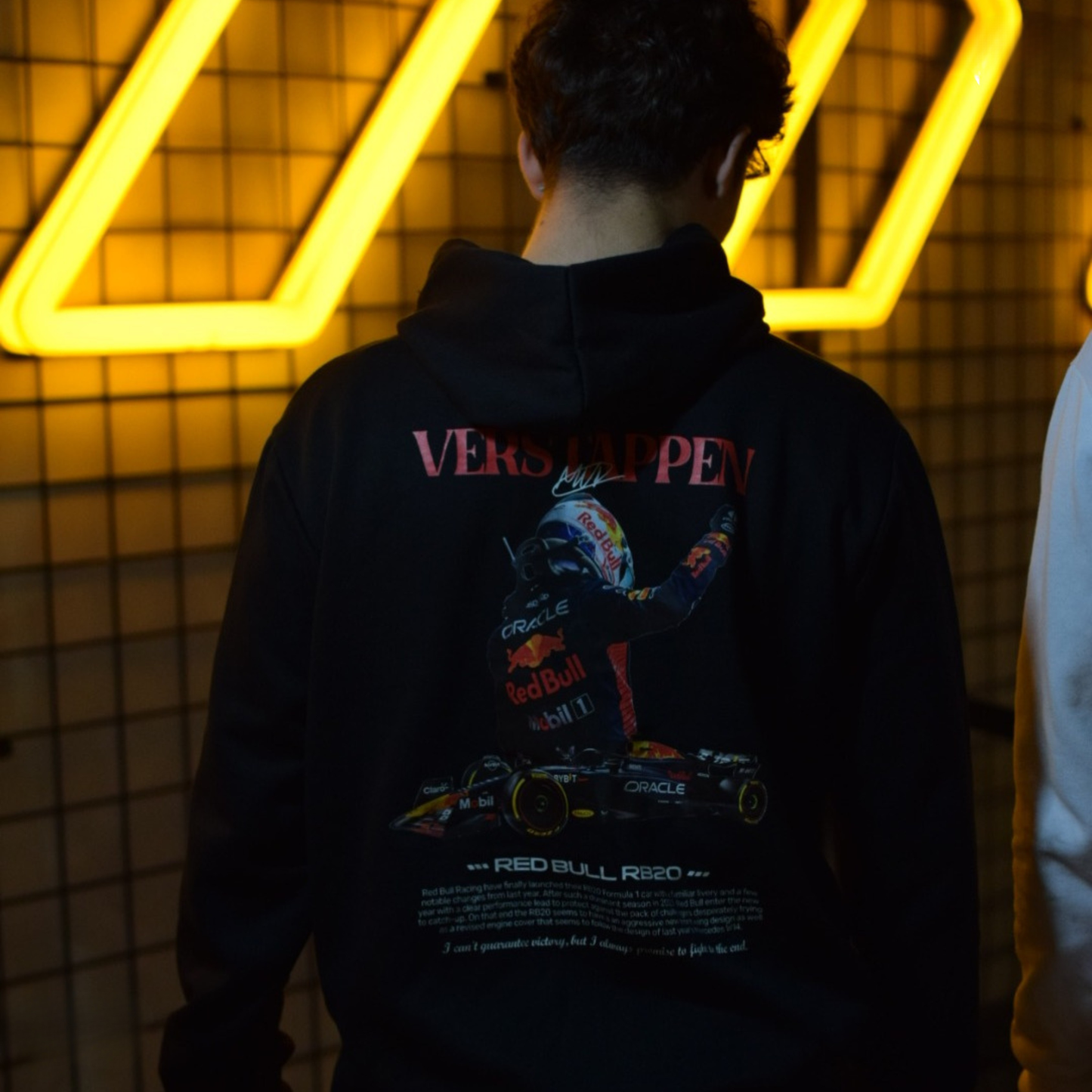 Black and white Formula 1 hoodies featuring Verstappen’s name and Red Bull RB20 car graphic on the back, and a minimalist red Formula 1 logo on the front chest