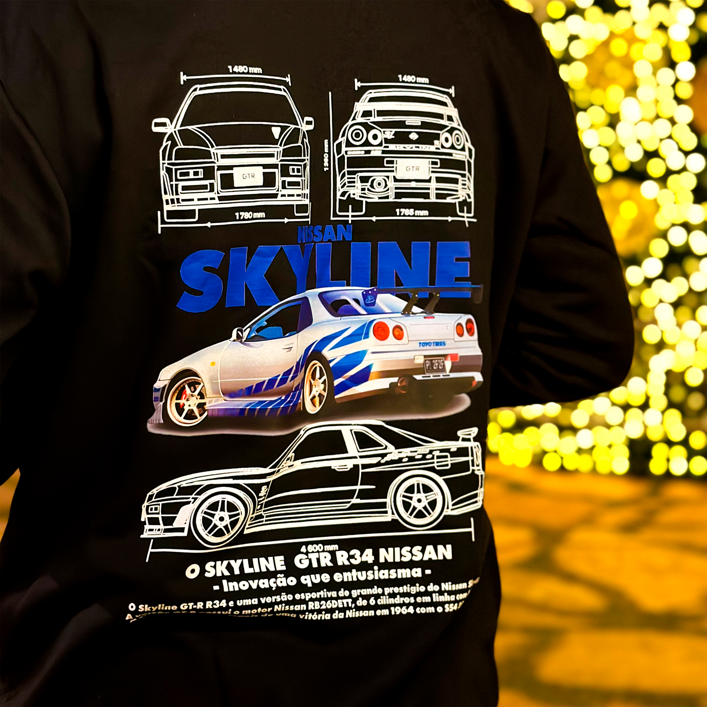 Black and white hoodies featuring the Nissan Skyline GT-R R34 blueprint design with technical views of the car and bold blue “SKYLINE” typography.